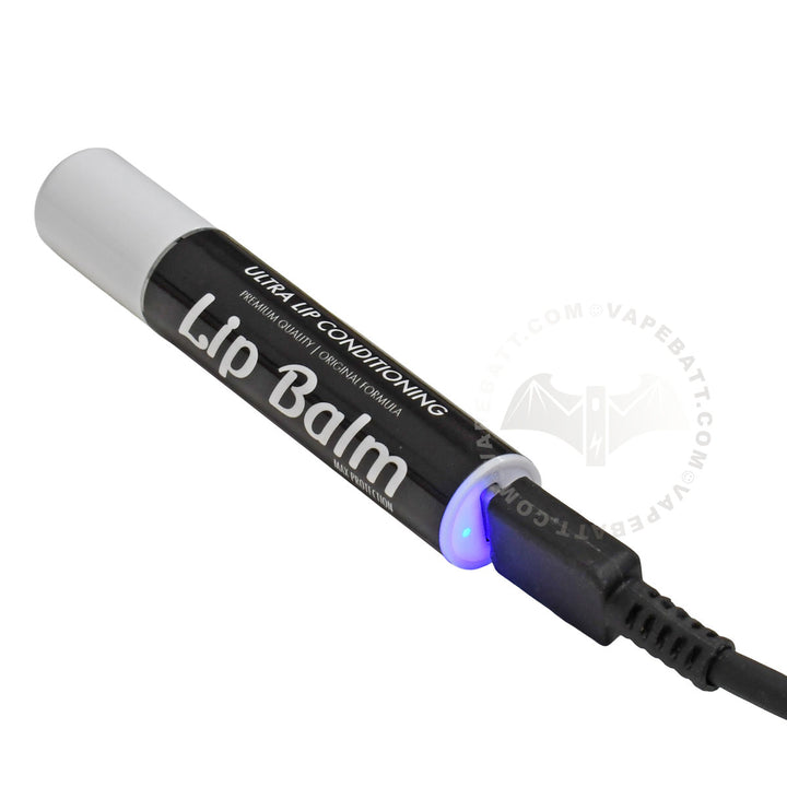 USB-C charging a lip balm cart pen battery with a black body, white cap, and a glowing blue LED light, shown on a white background